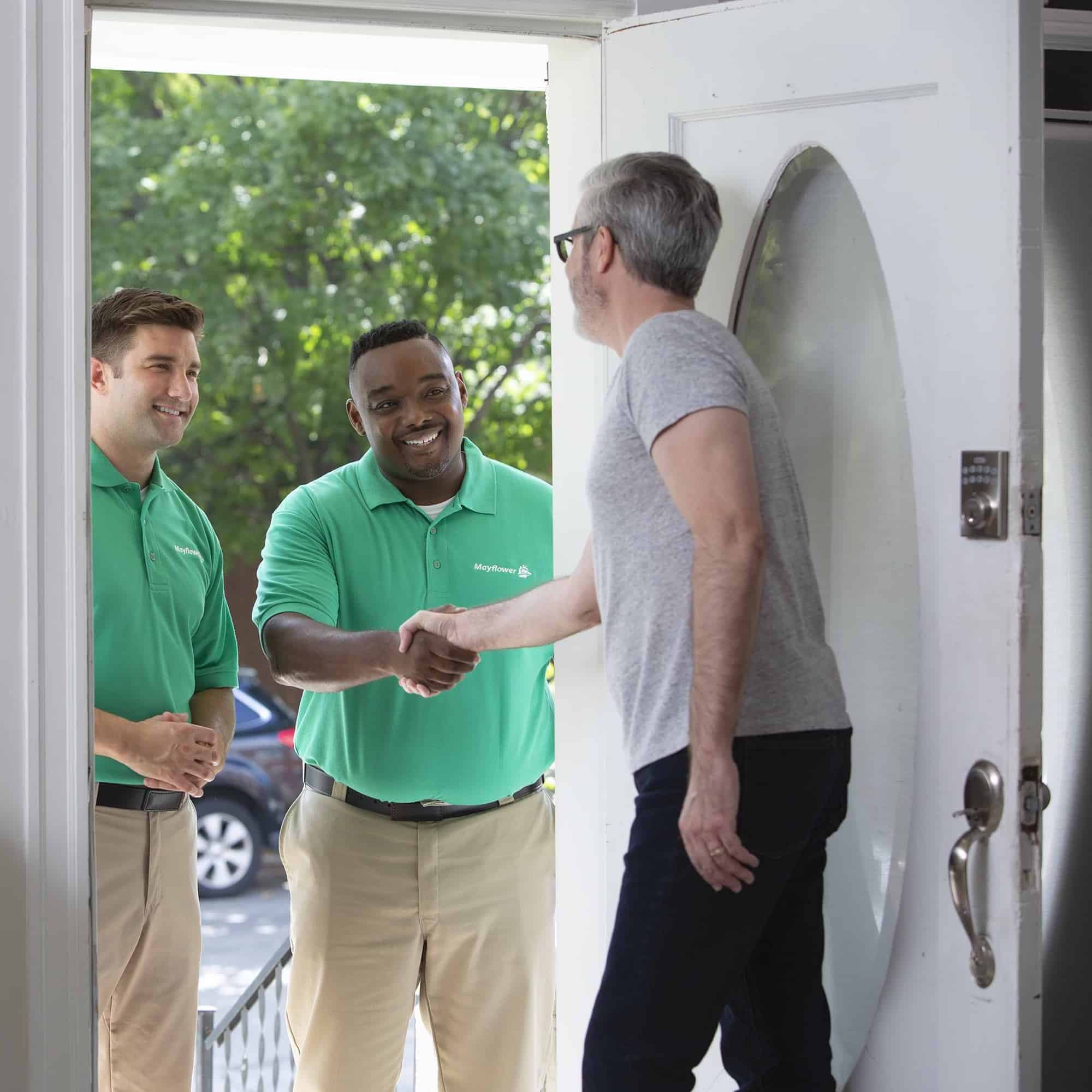 two Mayflower movers interacting with a customer in his doorway - Mayflower